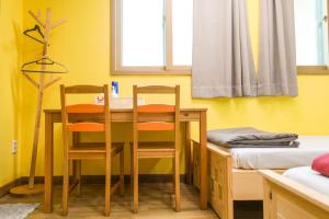 a room with a table and two chairs and a bed at Daegu Midtown Hostel in Daegu