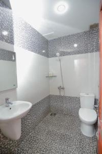 een badkamer met een wit toilet en een wastafel bij Lien Do Star Hotel in Bao Loc