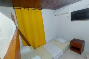 Habitación con 2 camas y cortina amarilla en Posada N Seaflower Lodge 2 en San Andrés
