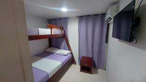 um pequeno quarto com 2 beliches e uma televisão em Posada N Seaflower Lodge 2 em San Andrés
