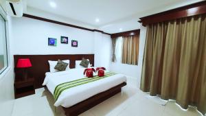 a bedroom with a large bed with red pillows at Fruit Paradise in Patong Beach