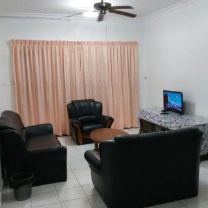 a living room with two chairs and a table and a television at Marina Court Stay In Borneo 01 in Kota Kinabalu