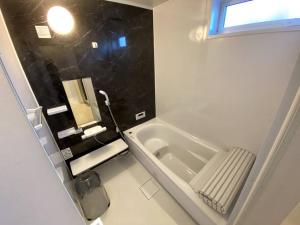 uma casa de banho com um lavatório e uma banheira em [Mt. Fuji koko]ワンちゃんOKの新築貸別荘 em Fujikawaguchiko