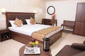 a hotel room with a large bed and a table at Hotel Diamond Inn in Chandīgarh