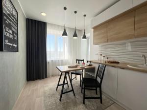 cocina con mesa y sillas en una habitación en Элитная квартира в центре, en Pavlodar