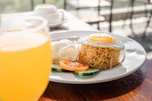a plate of food with rice and vegetables and a glass of beer at Del Cielo Villa Jimbaran in Jimbaran