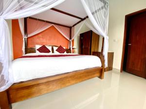 ein Schlafzimmer mit einem großen Bett mit Baldachin in der Unterkunft Ubud Mayura Private Pool Villa in Ubud
