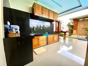 une cuisine avec des placards en bois et un comptoir noir dans l'établissement Ubud Mayura Private Pool Villa, à Ubud