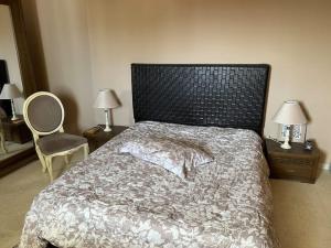 a bedroom with a bed and two chairs and two lamps at Botola Home 2 in Casablanca