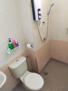 a bathroom with a white toilet and a shower at Cheerful 3-Bedroom Residential Home with Free WIFI in Butterworth