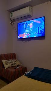sala de estar con TV de pantalla plana en la pared en Botanical house en San Miguel de Tucumán