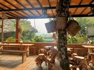 una terraza de madera con un árbol con maletas. en Puluong homestay1holiday en Pu Luong