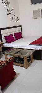OYO Raj Villas في Satna: سرير مع طاولة زجاجية في الغرفة