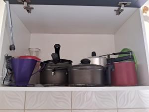 a shelf filled with pots and pans in a kitchen at Edward Suíte Manaus 01 in Manaus