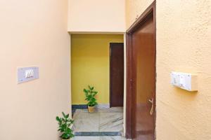 an open door to a hallway with a plant at OYO Flagship Advik Cottage in Khandagiri