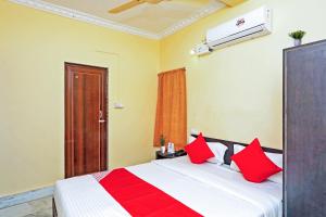 una camera da letto con un letto con cuscini rossi di OYO Flagship Advik Cottage a Khandagiri