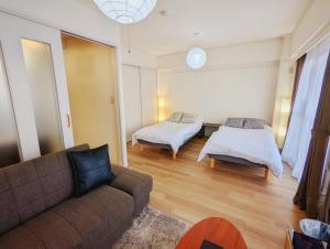 a living room with a couch and two beds at Amber Iidabashi - Vacation STAY 90436v in Tokyo