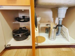 a kitchen cabinet with pots and pans in it at Amber Iidabashi - Vacation STAY 90436v in Tokyo