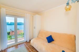 a living room with a couch and a large window at Pelješac Apartmani -Orsula in Kučište