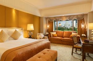 a hotel room with a large bed and a window at Anantara Siam Bangkok Hotel in Bangkok