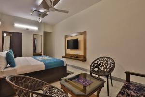 a hotel room with a bed and a tv at Super OYO Hotel Siddharth Inn in Gandhinagar
