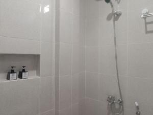La salle de bains est pourvue d'une douche avec une porte en verre. dans l'établissement Urbanview Badran Residence Syariah Manahan, à Solo
