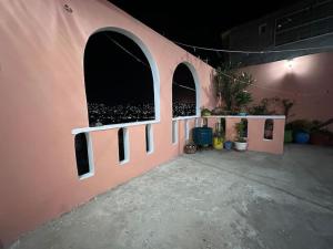 een roze muur met gebogen ramen in een gebouw bij Estancia Luna in Salina Cruz