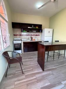 een keuken met een tafel en een bureau in een kamer bij Estancia Luna in Salina Cruz