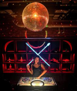a woman standing at a poker table with a disco ball at SocialTel Koh Samui in Chaweng