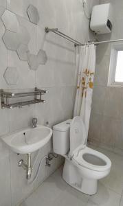 Baño blanco con aseo y lavamanos en Rumah Bahagia 36 en Bonorejo