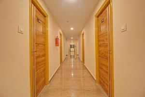 un corridoio con due porte in legno e un lungo corridoio di Super Townhouse 733 Whiteridge Gachibowli Near AIG Hospital a Hyderabad