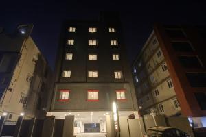 un edificio alto con ventanas iluminadas en una ciudad por la noche en Super Townhouse 733 Whiteridge Gachibowli Near AIG Hospital, en Hyderabad