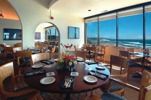 ein Esszimmer mit einem Tisch und Stühlen sowie Meerblick in der Unterkunft Inn at Spanish Head Resort Hotel in Lincoln City