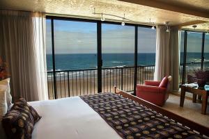 a bedroom with a bed and a view of the ocean at Inn at Spanish Head Resort Hotel in Lincoln City