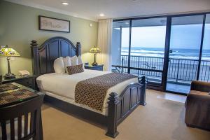 ein Schlafzimmer mit einem Bett und einem Balkon mit Meerblick in der Unterkunft Inn at Spanish Head Resort Hotel in Lincoln City