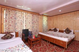 帕哈尔加姆Hotel Bright Palace的有两张床和一张桌子的酒店房间