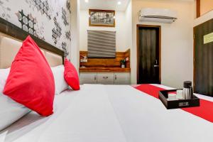 una camera con due grandi letti con cuscini rossi di Super OYO Flagship Hotel Sky Land a Ludhiana