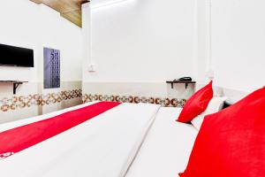 a bedroom with red pillows and a red bed at OYO Hotel Paradise Inn in Jodhpur