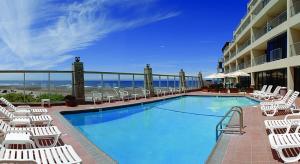 a swimming pool with white chairs and a hotel at Inn at Spanish Head Resort Hotel in Lincoln City