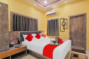 a bedroom with a large white bed with red pillows at Avenue Inn Near Birla Mandir in Kolkata
