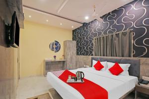 a bedroom with a large bed with red pillows at Avenue Inn Near Birla Mandir in Kolkata