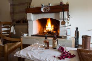 a table with wine glasses and a fireplace at B&B Dolomitincanto in Cesiomaggiore