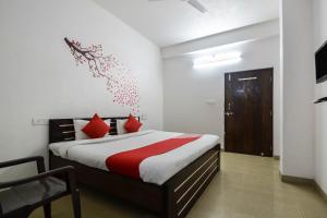 a bedroom with a bed with red pillows at OYO Hotel Saniya Udaipur in Udaipur