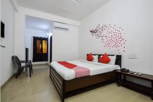 a bedroom with a bed and a desk with red pillows at OYO Hotel Saniya Udaipur in Udaipur