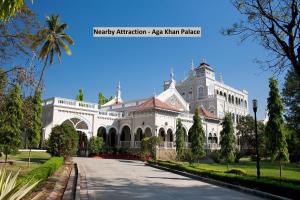 a large white building with a palm tree at Super Collection O Sunshine Near Inox in Pune