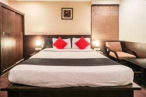 a bedroom with a large bed with red pillows at Capital O Hotel Krishna in Jaipur