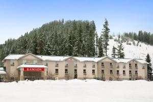 a large building in the snow in front of a mountain at Ramada Golden in Golden