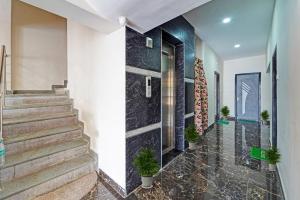 un couloir avec des escaliers et des plantes en pot dans l'établissement Capital O Hotel Lakshmi Residency, à Tirupati