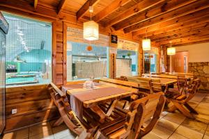 a dining room with wooden tables and chairs at Hotel Tenis in Chrząstowice