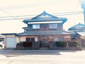 a house with an asian roof on a street at 高島市マキノ町民泊お得 in Takashima